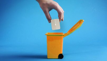 a human hand putting the application icon for file roller into an orange recycle bin against a blue background